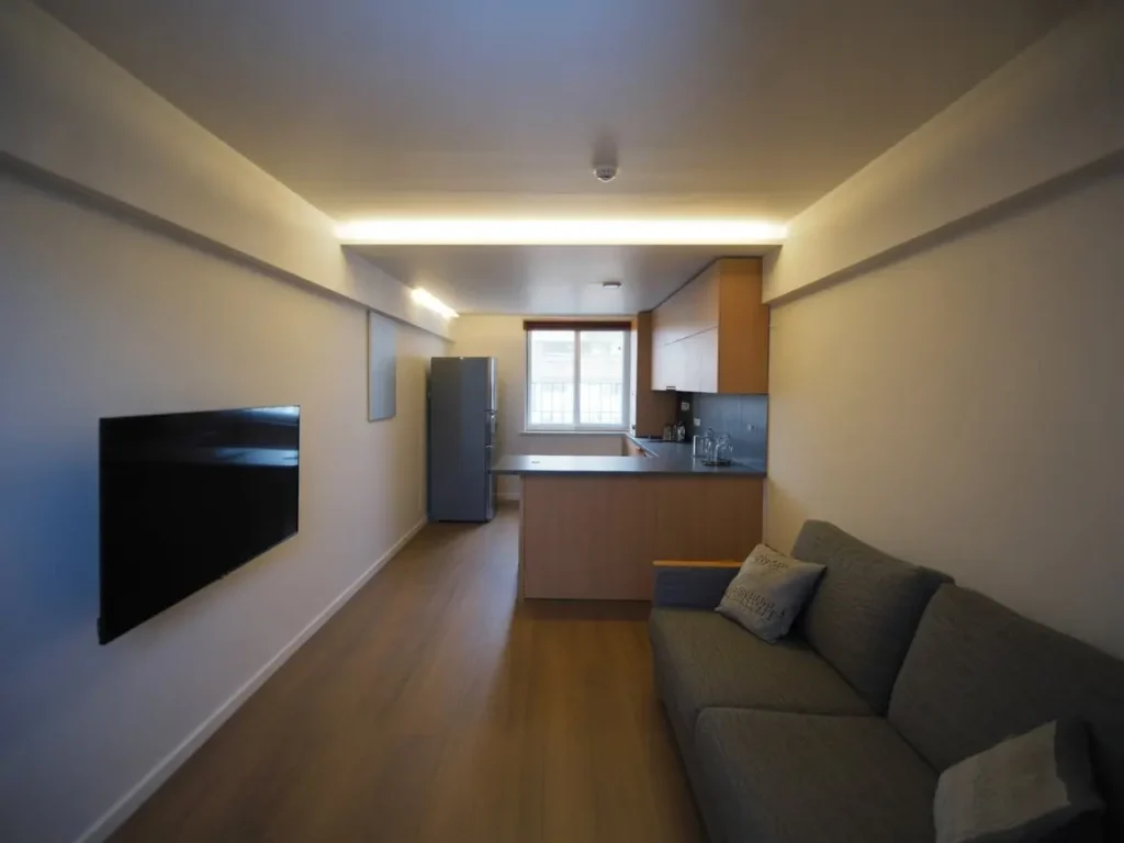 Salón con cocina integrada y techo continuo de pladur con iluminación indirecta en Albacete